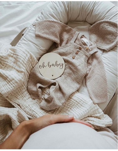 Cozy baby clothes used in a winter pregnancy announcement