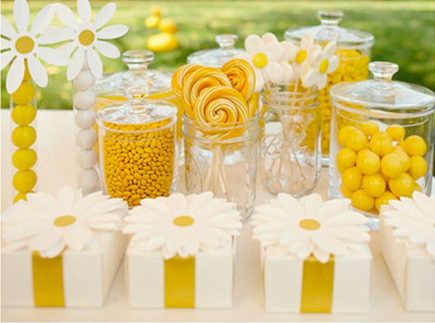 Table decorated with yellow accents and daisy-themed decor for a baby shower