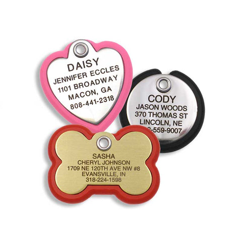 stainless heart shaped tag with neon pink frame, stainless round tag with black frame, and a brass bone shaped tag with red frame
