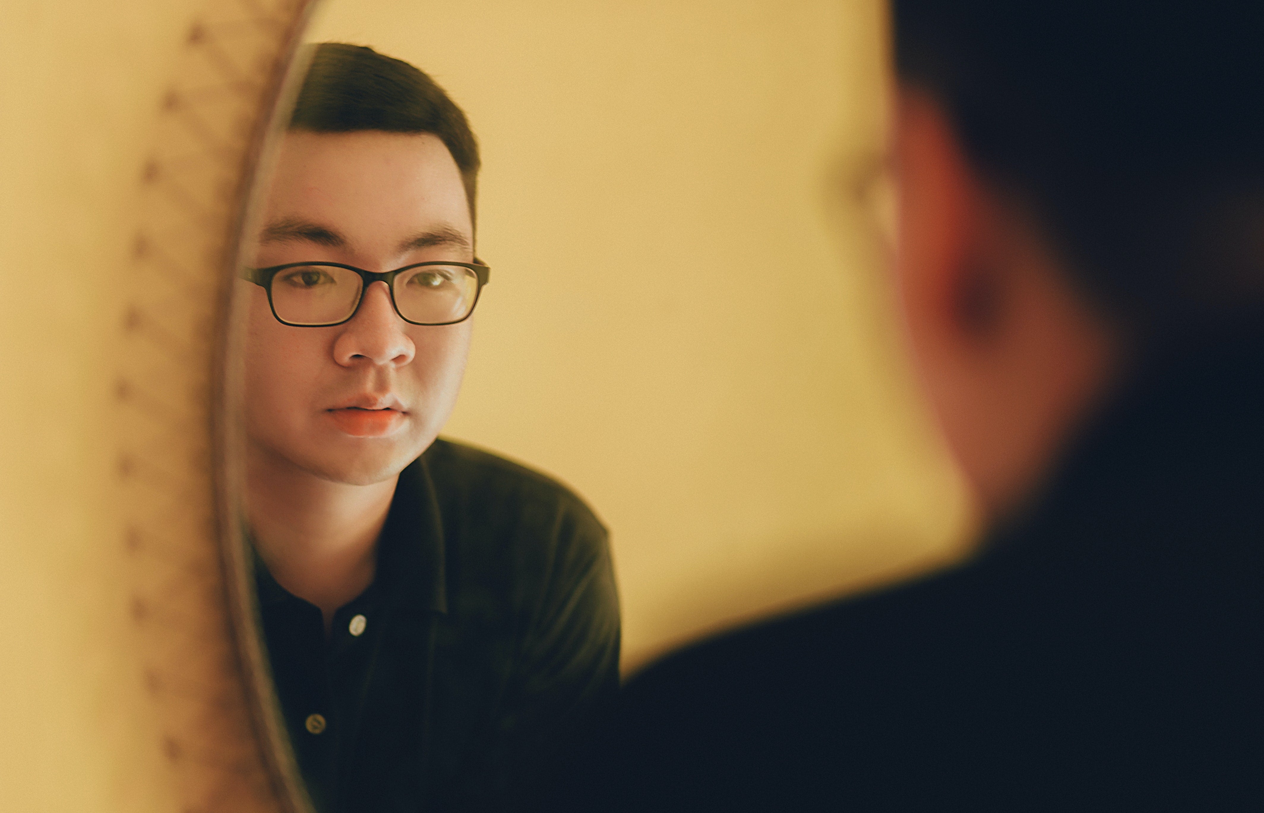 Asian man looking into a mirror   