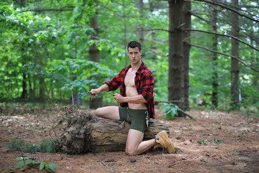 Man in the jungle dressed in a plaid shirt and boxers