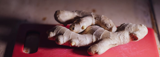 Fresh ginger placed on a red chopping board