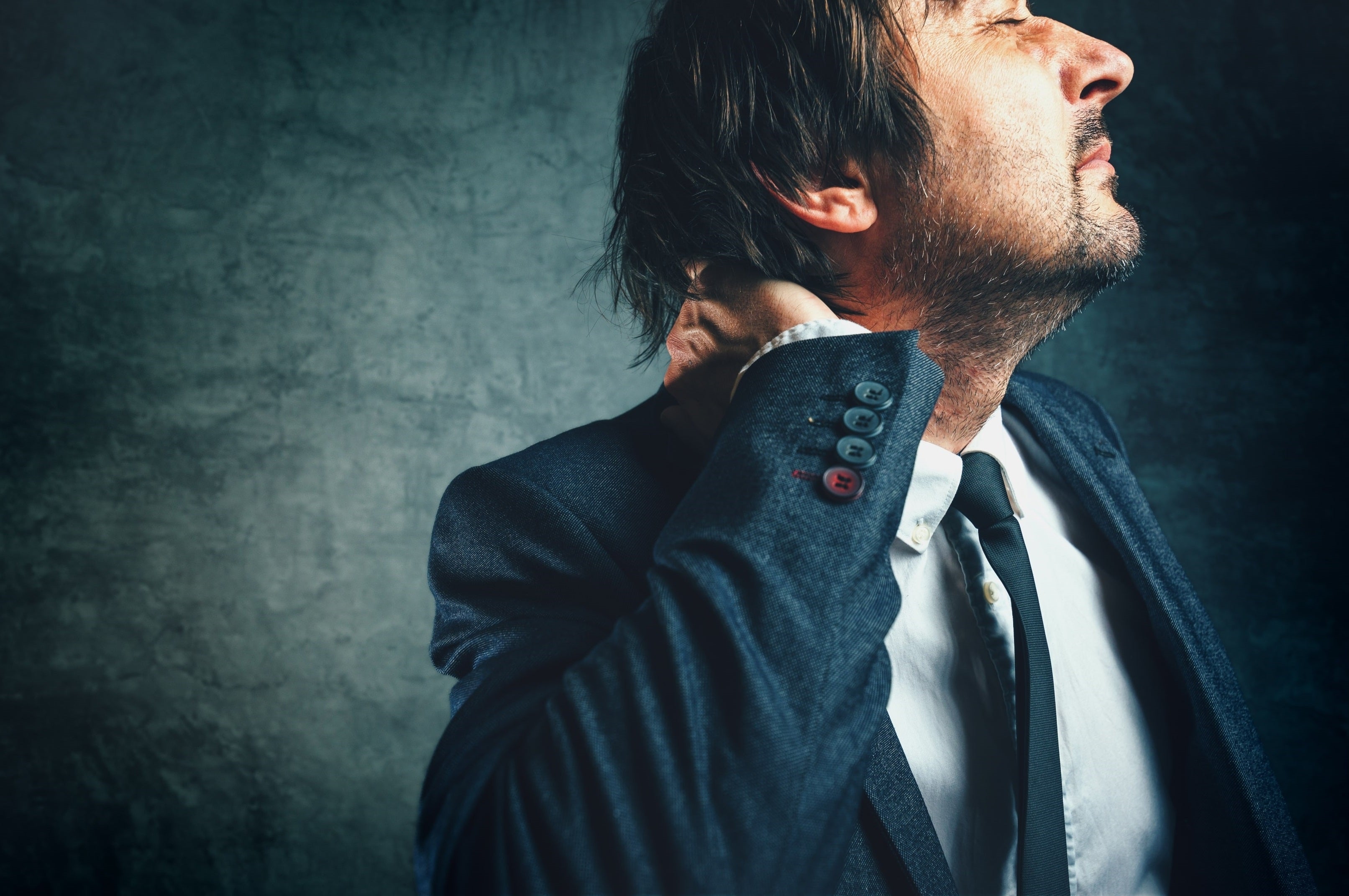 Image of a man holding neck in pain