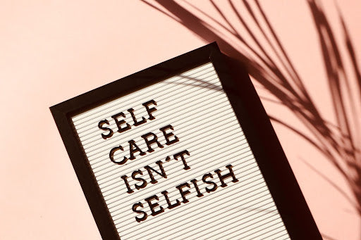 Image of a board with a self care is not selfish sign 