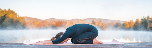 Woman on Yoga mat in child’s pose 