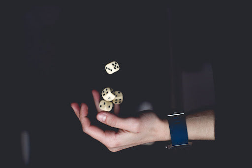 Man’s hands with a watch and many sets of dice in his hand