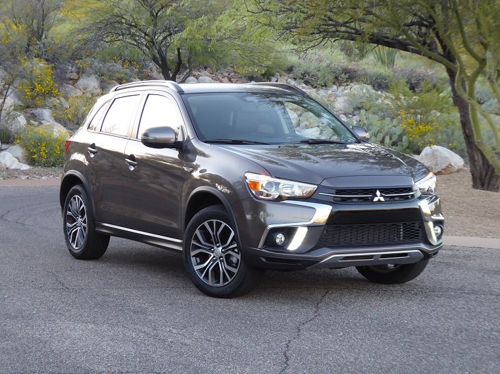 A smokey black Mitsubishi Outlander Sport S parked on a road in the wilderness