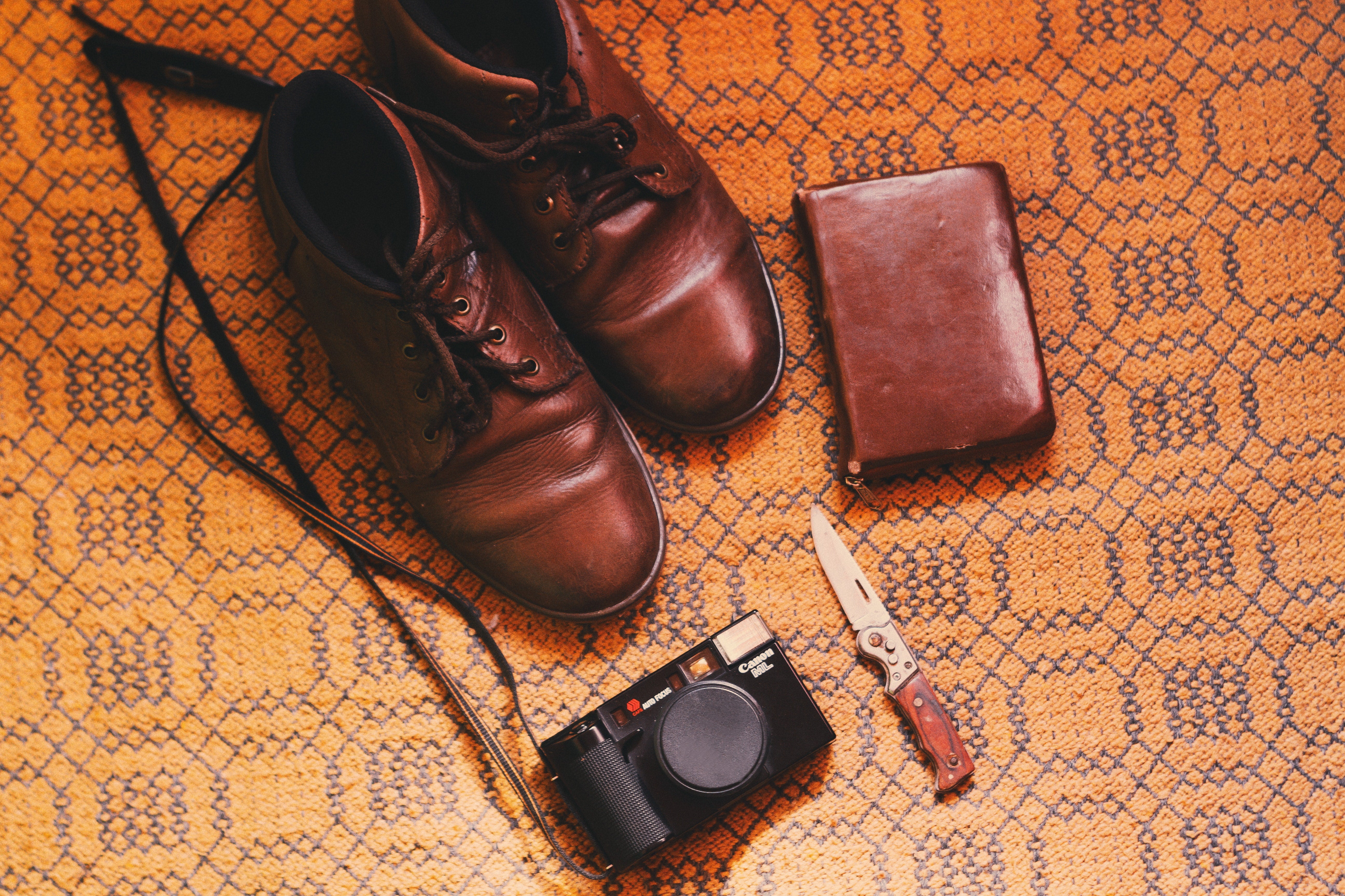 Image with a pair of shoes, wallet and a camera on the floor