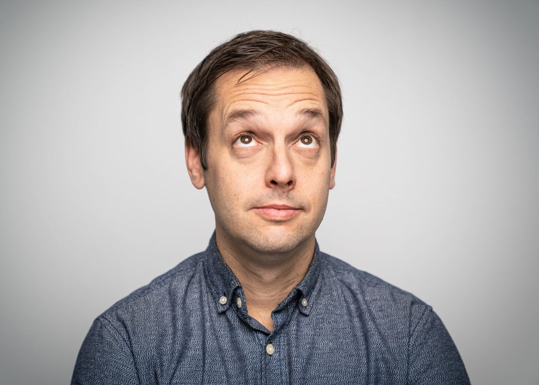 White male against plain colored background with raised eyebrows  