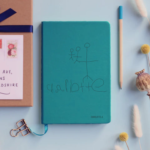 a personalised notebook in turquoise, engraved with a child's own drawing