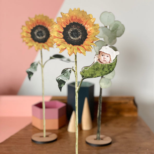 Newborn baby nestled in a wooden sunflower leaf gift for mother's day