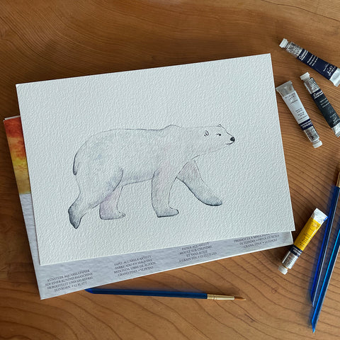 watercolour polar bear with some paints and paintbrushes around