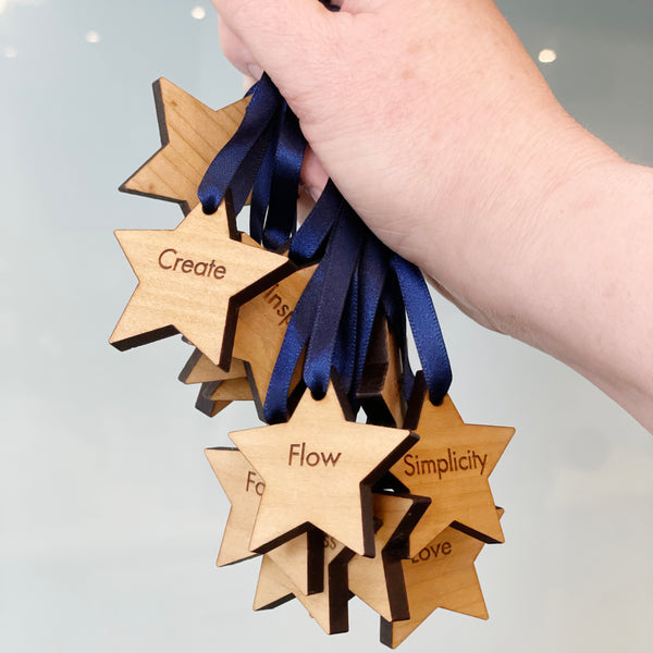 Cluster of wooden word of the year stars being held by their navy ribbons