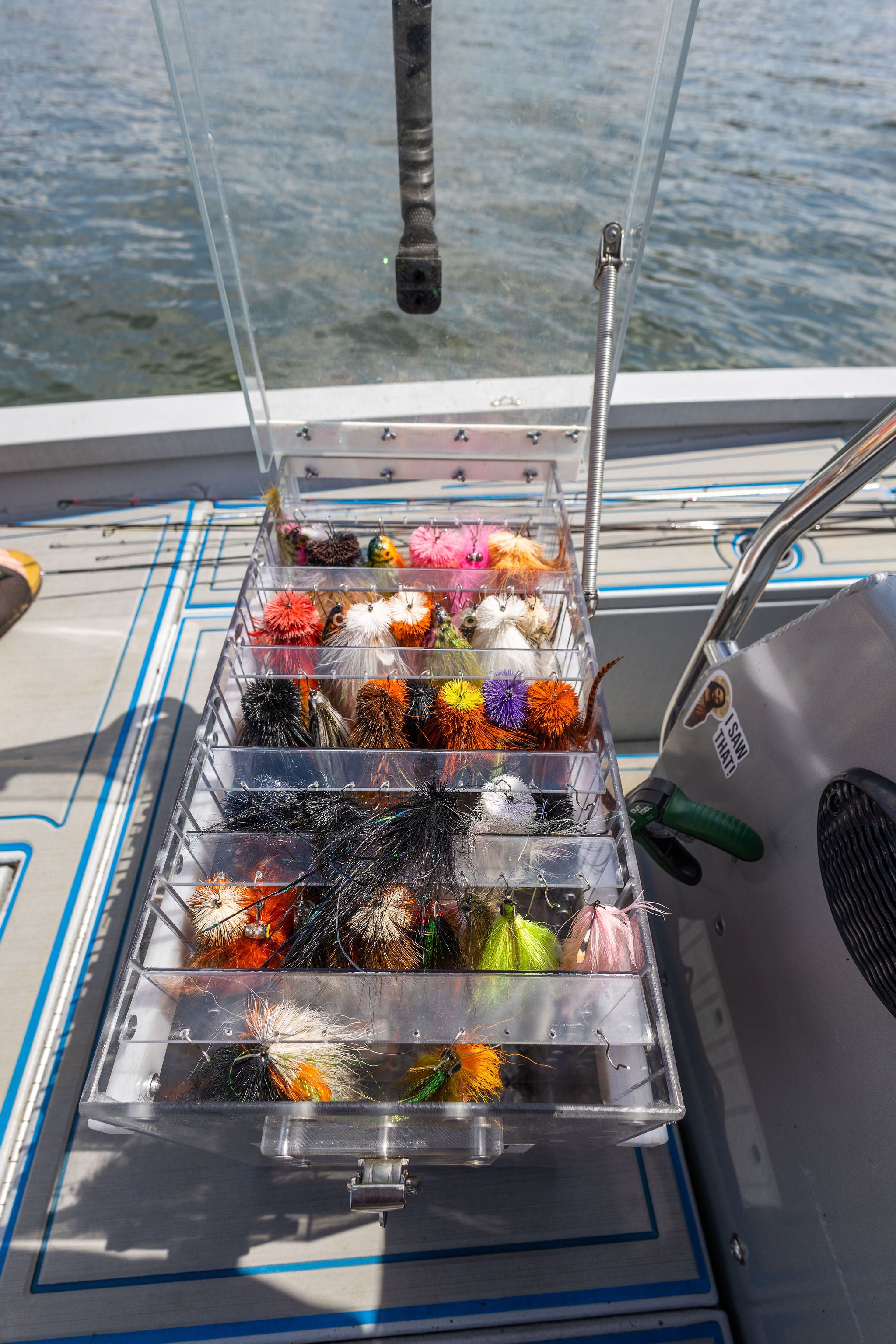 A clear tackle box with various fly fishing lures 