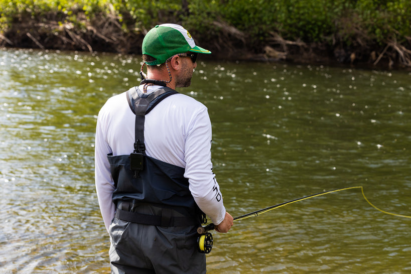 Fisherman with his back turned to the camera, while fly fishing