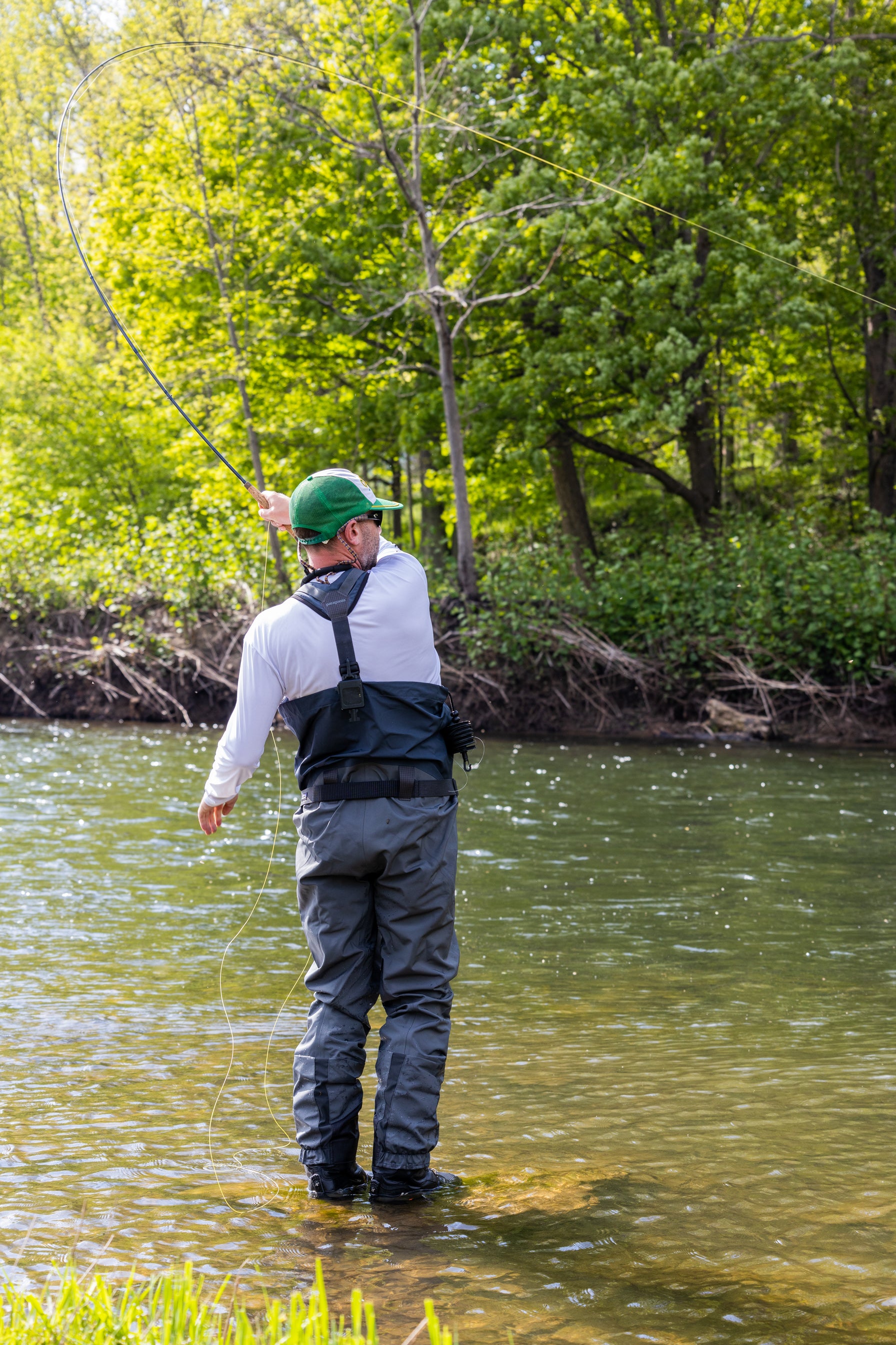 Fisherman casting out his line while dry fly fishing