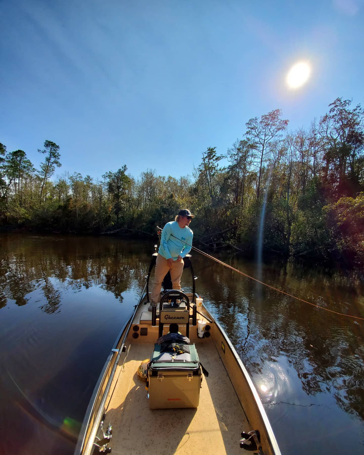 Fisherman holding onto his fly fishing rod on his boat