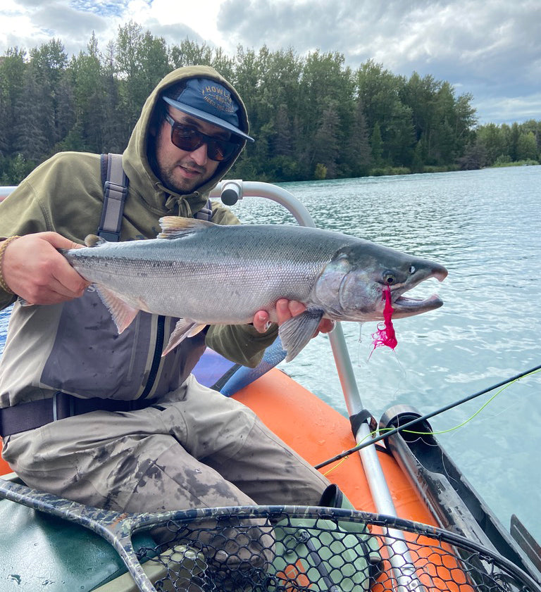 Matt Borovy is on a boat and holding onto a salmon