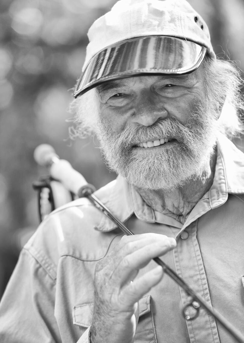 Flip smiling with a fly fishing rod over his shoulder