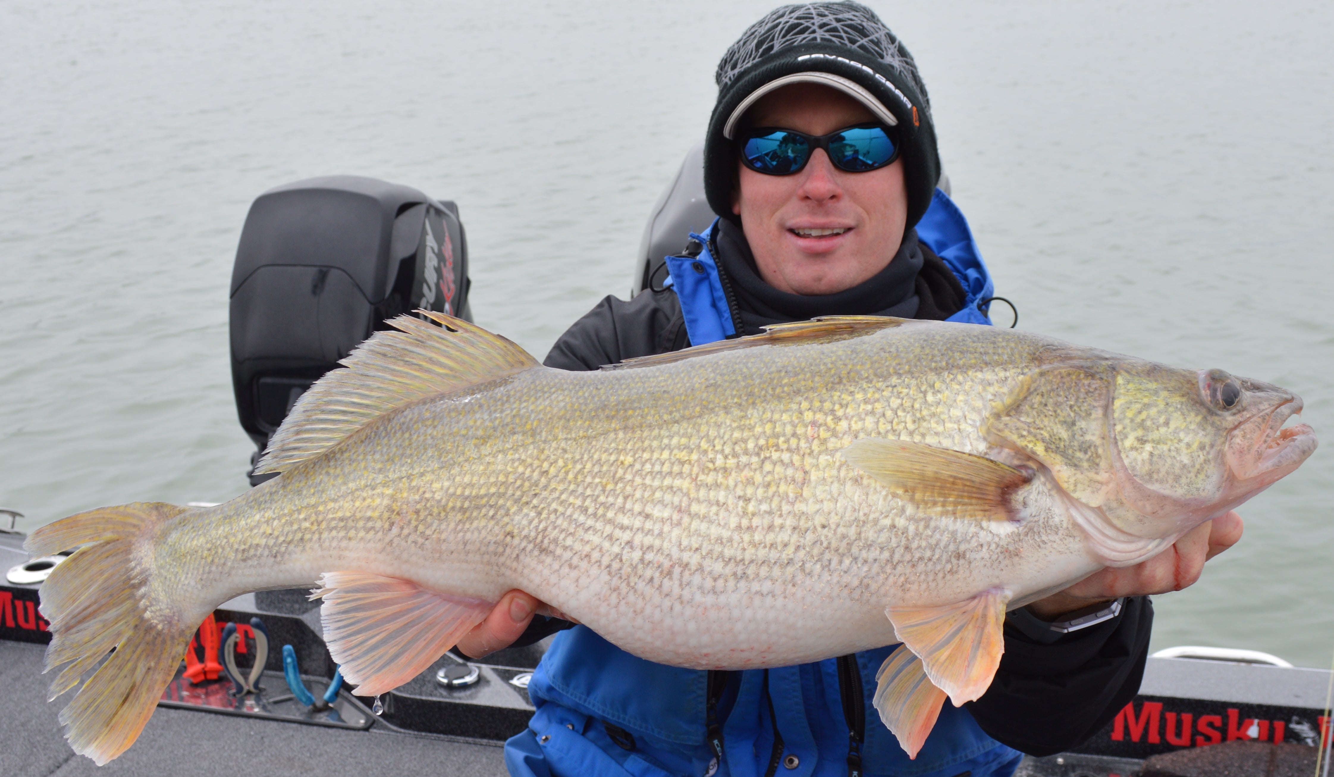 Man holding up a large walleye he caught 