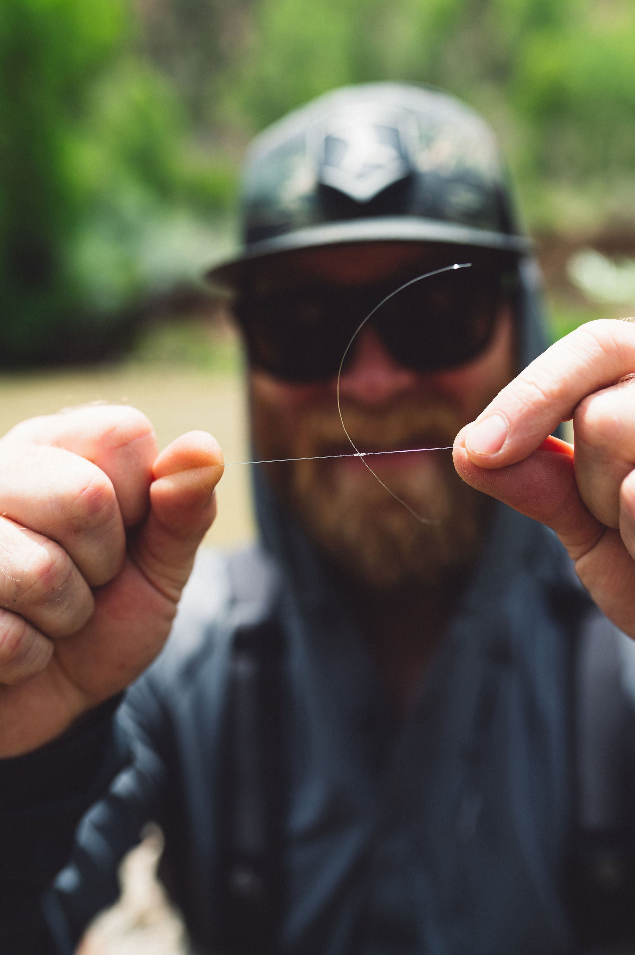 Ein Angler macht einen Knoten in seine Monofilamentschnur