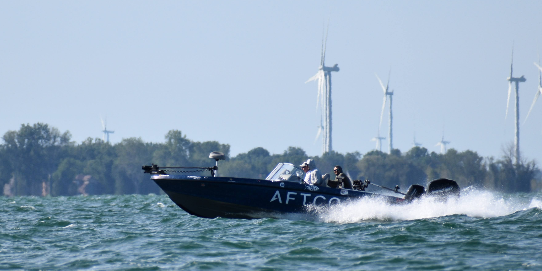 Boot auf dem Eriesee mit Windmühlen im Hintergrund