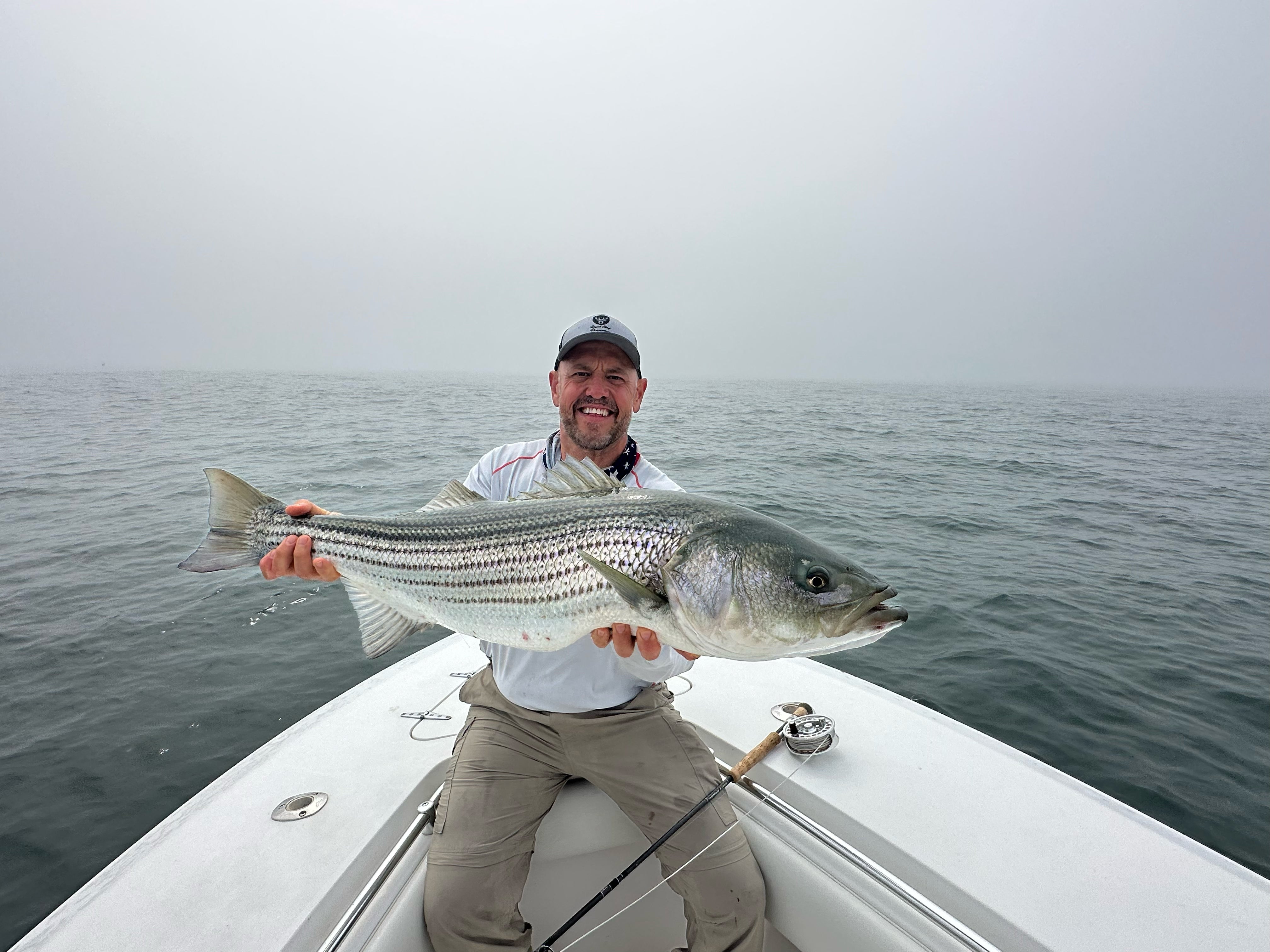 An angler holding a fish on a boat