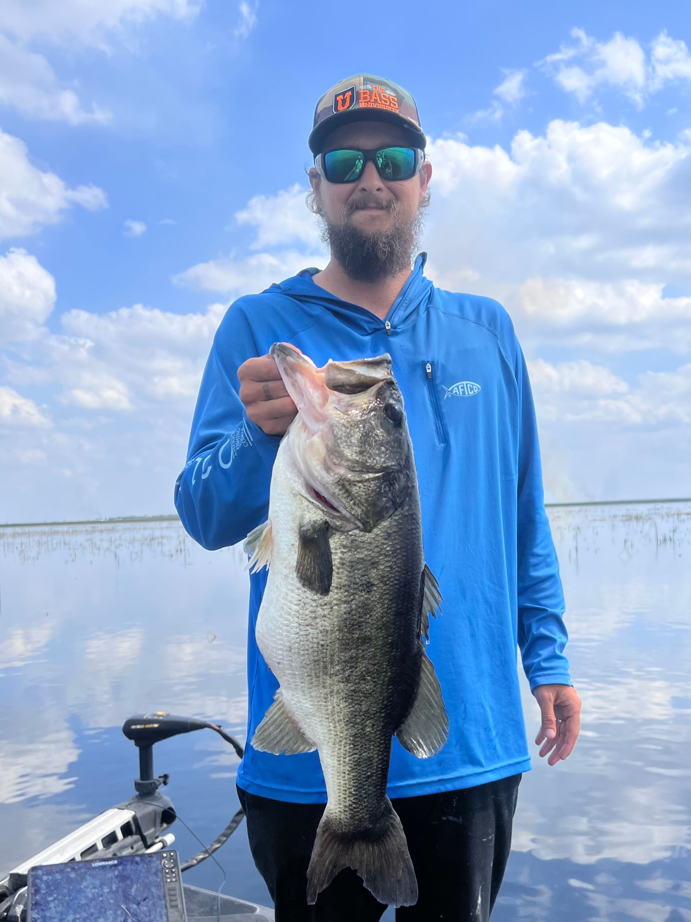 Fisherman holding up a bass he caught