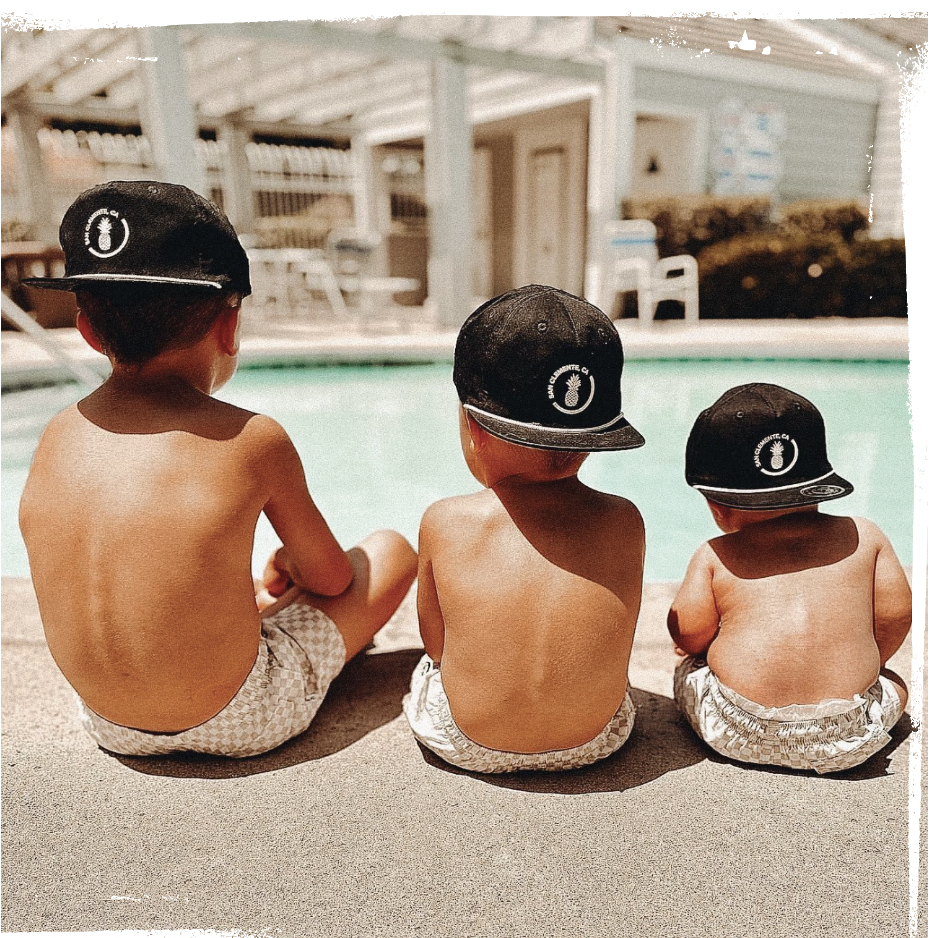 baby brothers with matching binkybro swimsuits and snapbacks