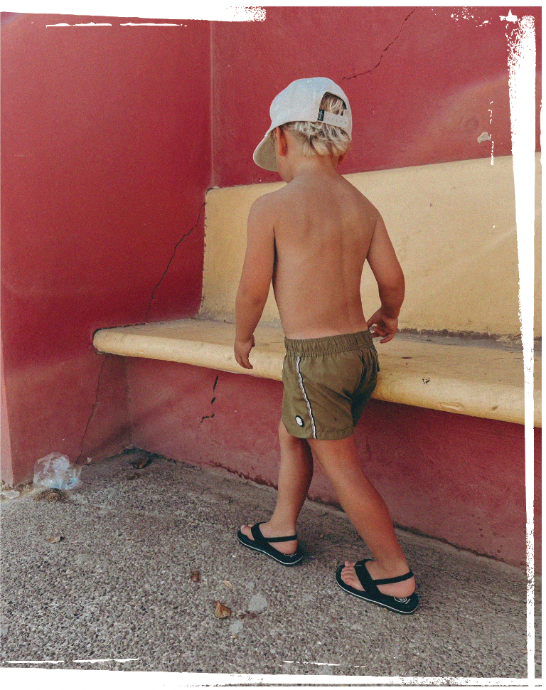 toddler with binkybro snapback and swimming trunks