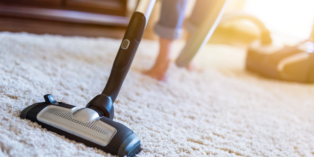 Image of person vacuuming carpet