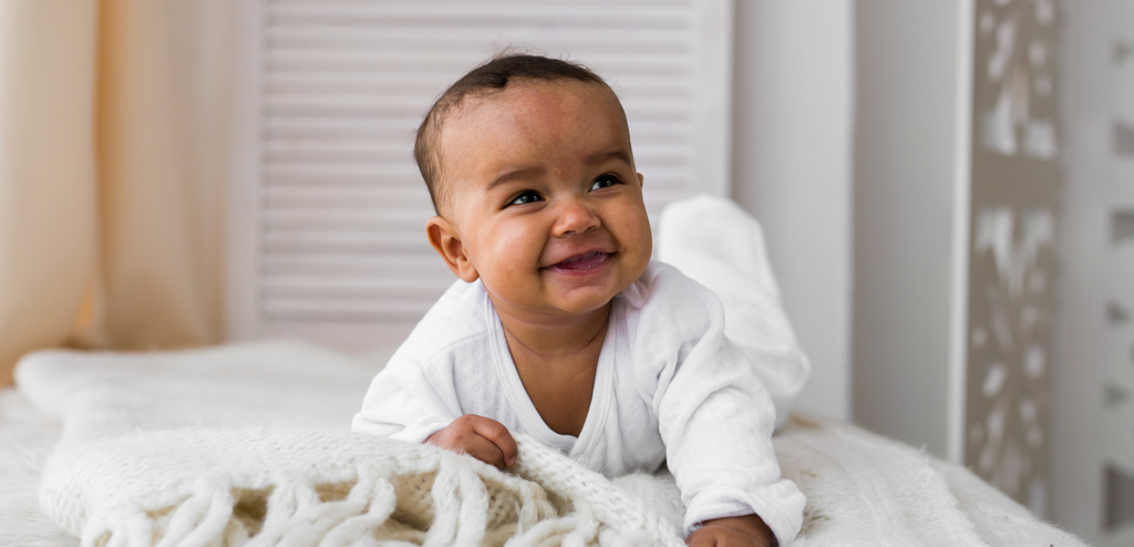 Baby smiling on bed