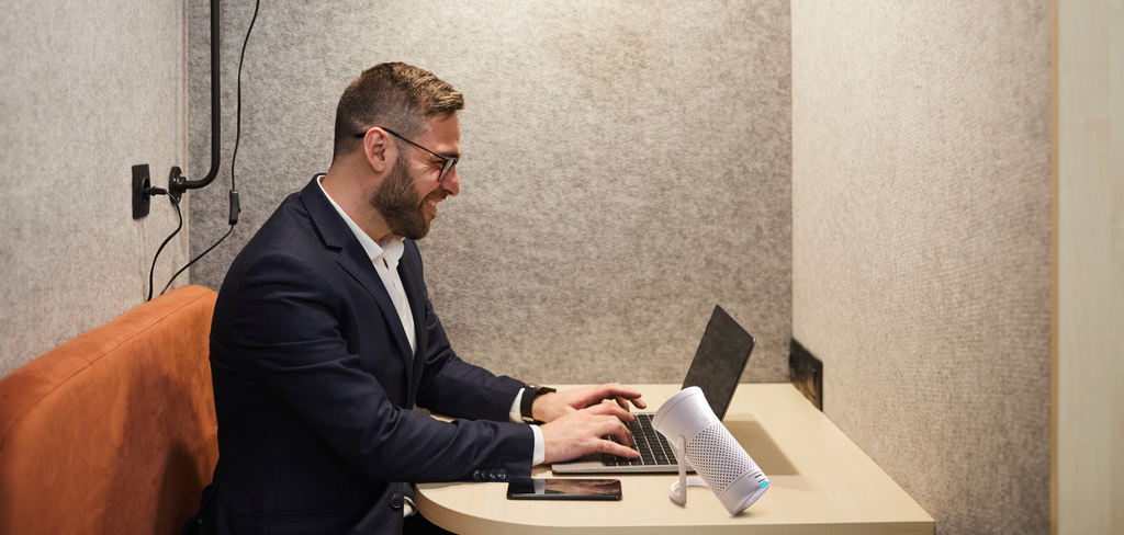 Image of man working at a desk with Wynd Personal Air Purifier