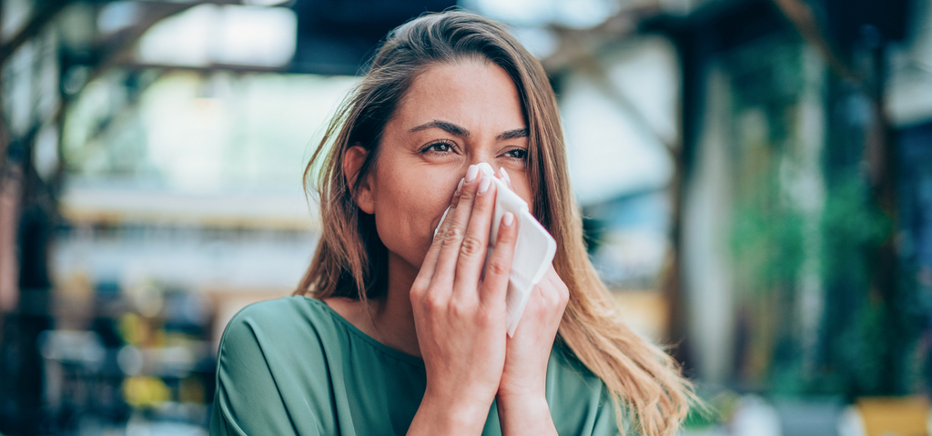Image of a woman sneezing with fall allergies