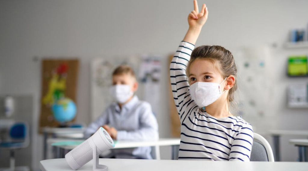 Child in classroom with Wynd Plus Air Purifier on desk