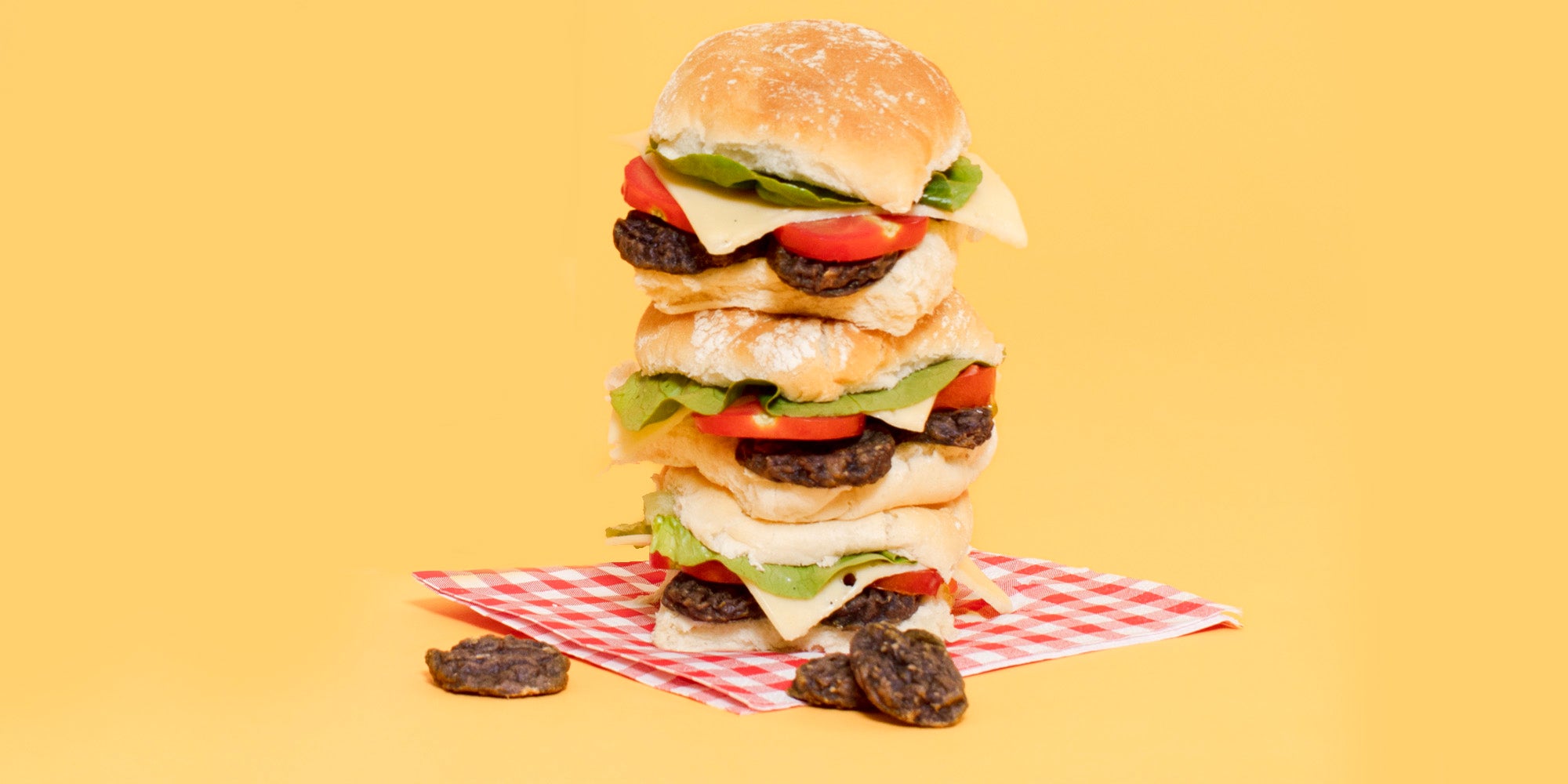 A burger made of Pooch & Mutt Smokin' BBQ Burgers on an orange background