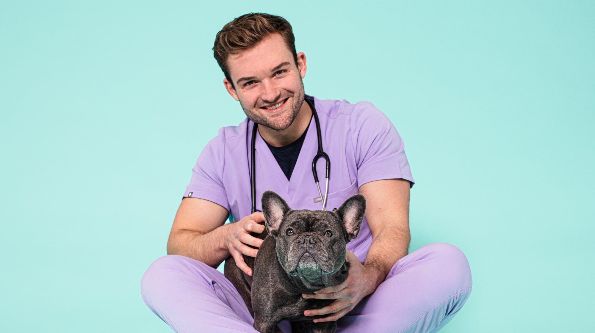 vet with a french bulldog on a blue background