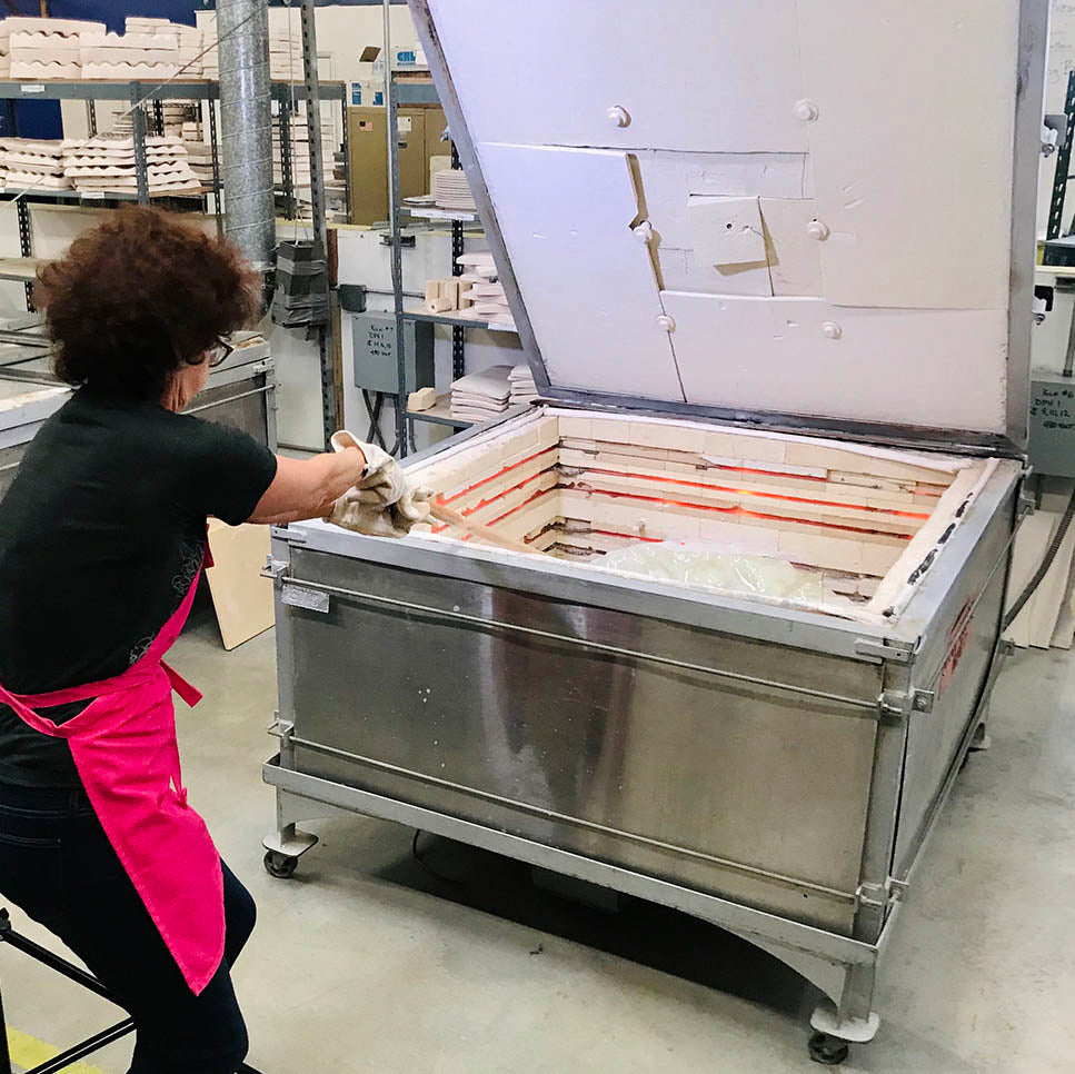 Annie Morhauser working with glass in the kiln.