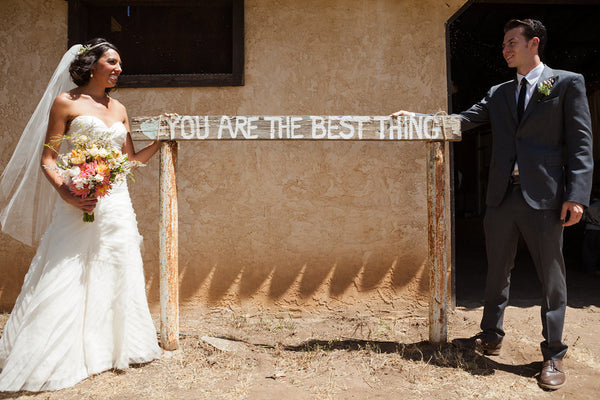 bridge and groom next to wedding sign