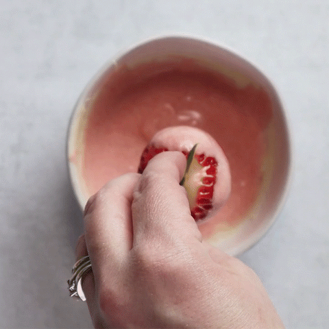 Dipping strawberry in melted chocolate