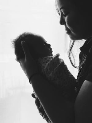 woman holding swaddled baby