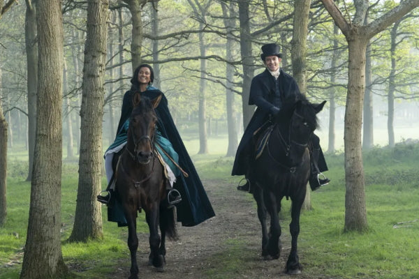 Simone Ashley and Jonathan Bailey in the latest season of Bridgerton riding horseback through the woods
