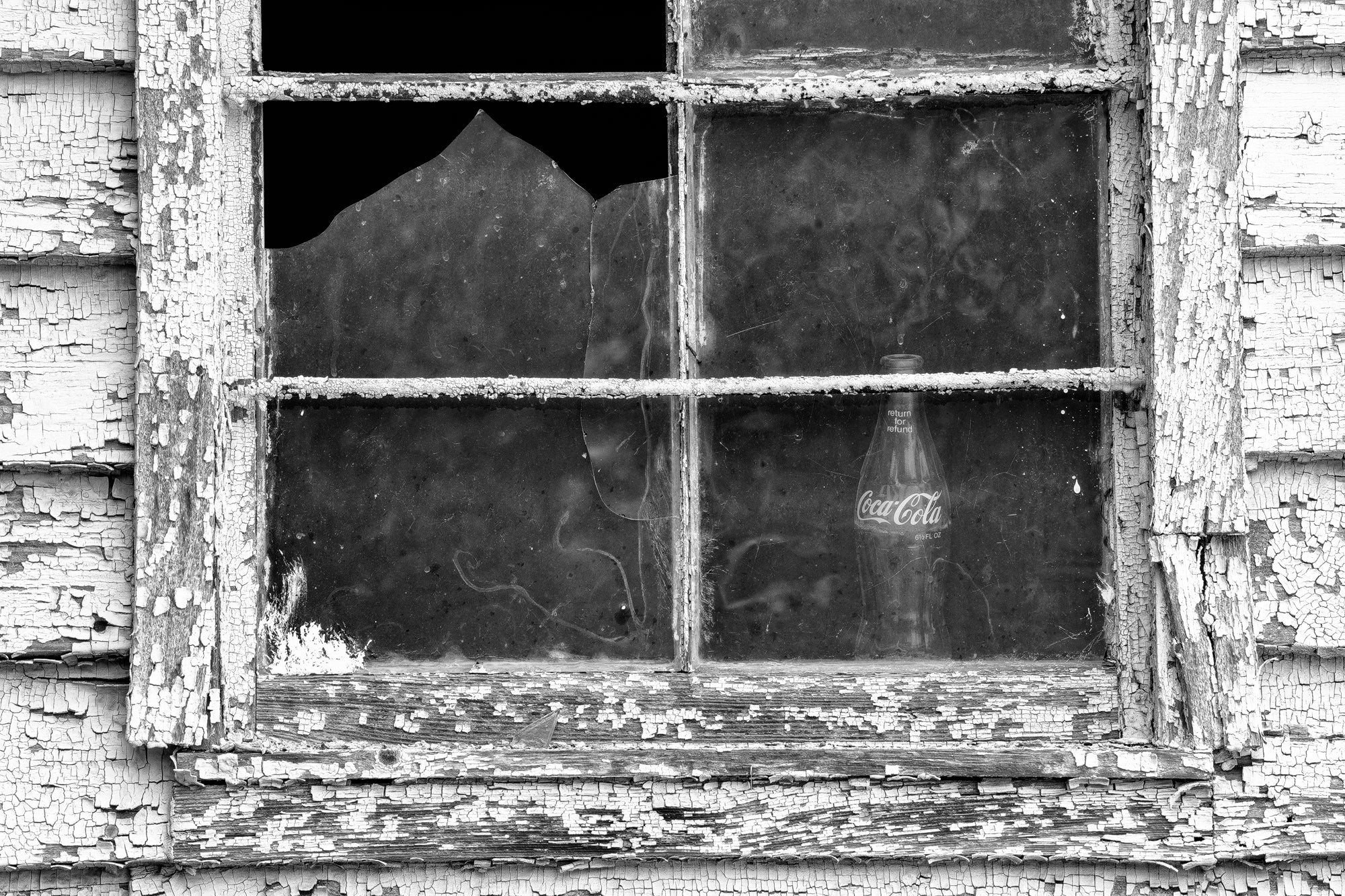 Window with Empty Cola Bottle - Black and white photograph by Keith Dotson.