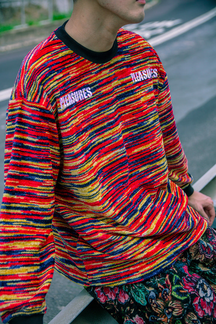 PLEASURES spring-summer 2022 model wearing Omaha Knit Sweater in a Multi-Color Red