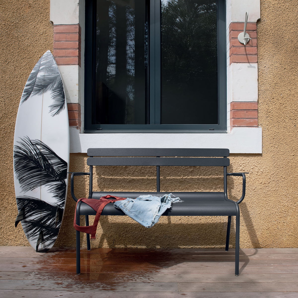 Fermob Luxembourg 2-Seater Garden Bench outside next to surfboard