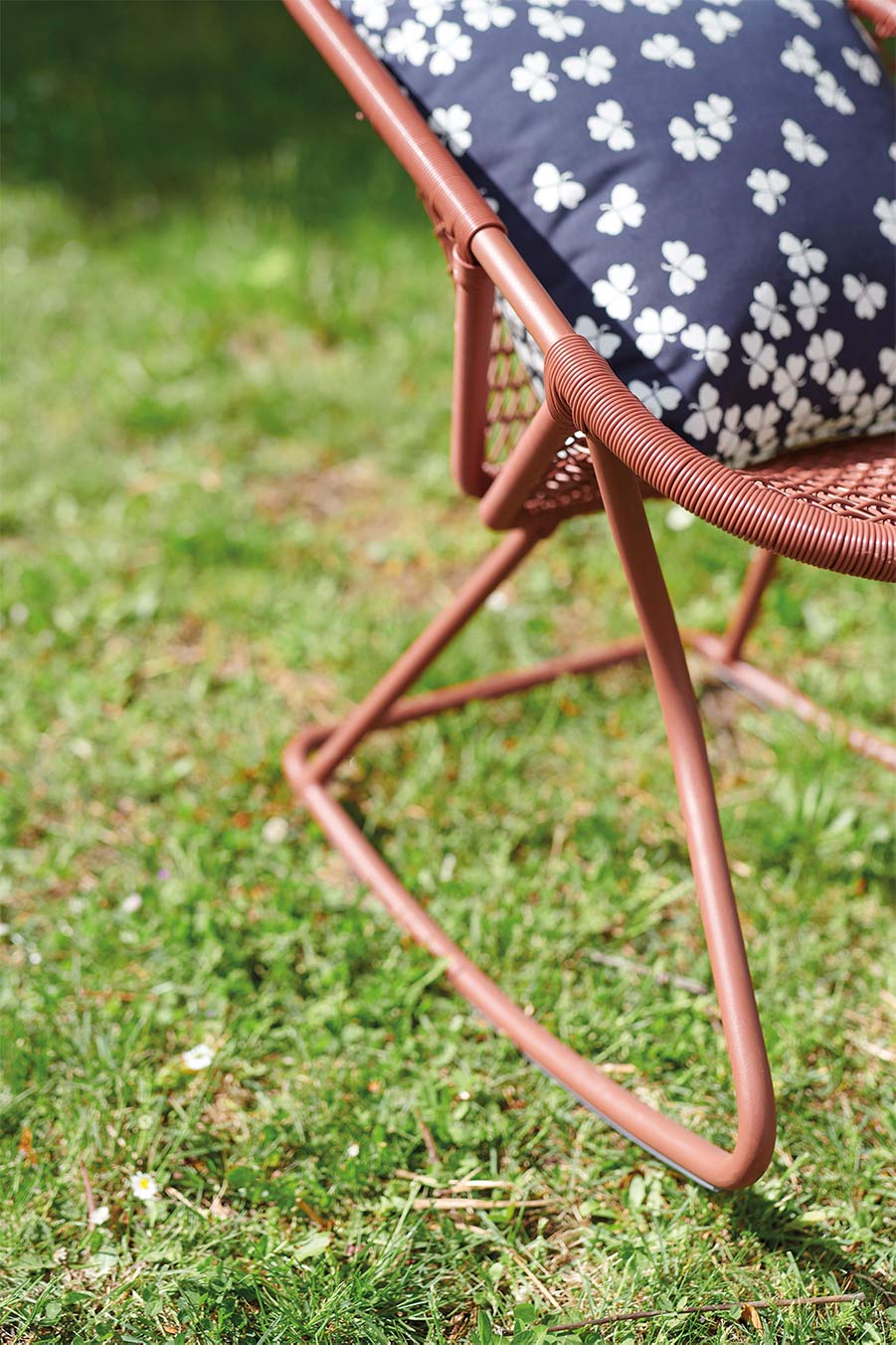 Fermob Sixties Rocking Chair in Red Ochre on outdoor lawn