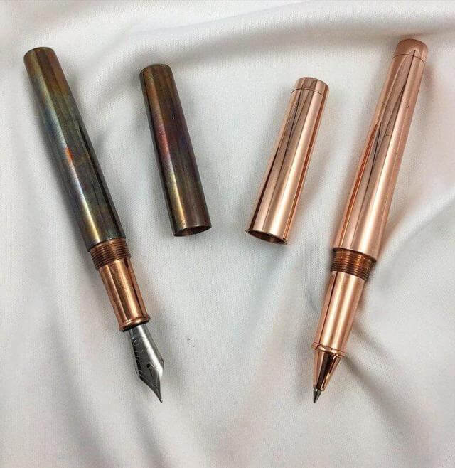 two copper pen cap open left pen with patina right pen clean shiny