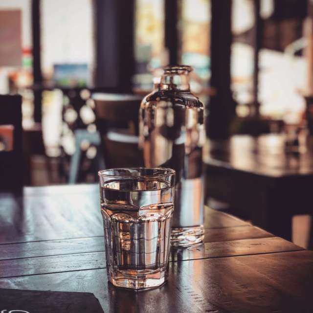 glass of water and bottle placed on a table restaurant setting