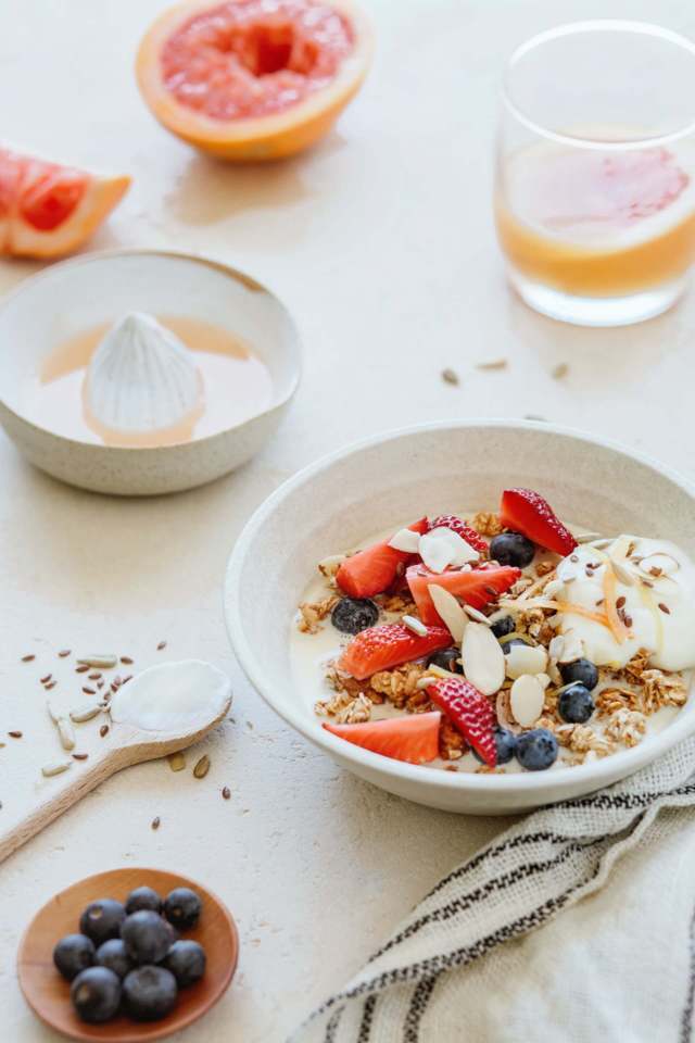 white bowl with oats blackberries strawberries almonds and yogurt