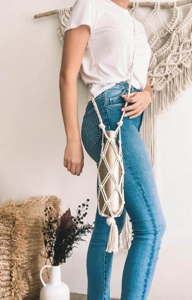 woman wearing white shirt blue jeans slinging macramé water holder